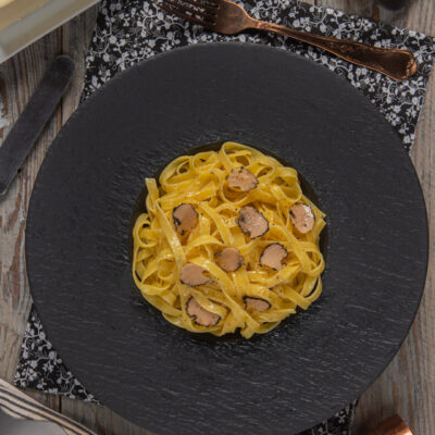 Tagliatelle al tartufo con lamelle di tartufo nero e condimento al burro