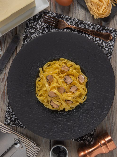 Tagliatelle al tartufo con lamelle di tartufo nero e condimento al burro