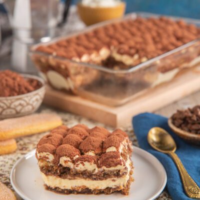Tiramisù classico in porzione con strati di crema al mascarpone, savoiardi e cacao in polvere
