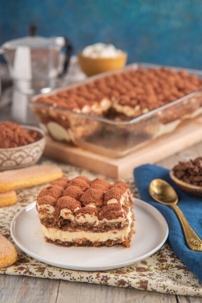 Tiramisù classico in porzione con strati di crema al mascarpone, savoiardi e cacao in polvere