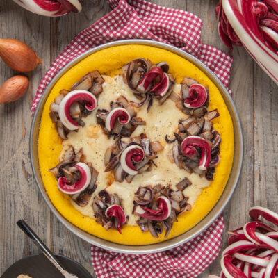 Torta di polenta con radicchio spadellato e fonduta di taleggio filante, servita in teglia