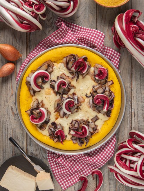 Torta di polenta con radicchio spadellato e fonduta di taleggio filante, servita in teglia
