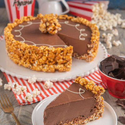 Torta popcorn con mousse al cioccolato: una fetta rivela la crema densa, con bordo di popcorn caramellati