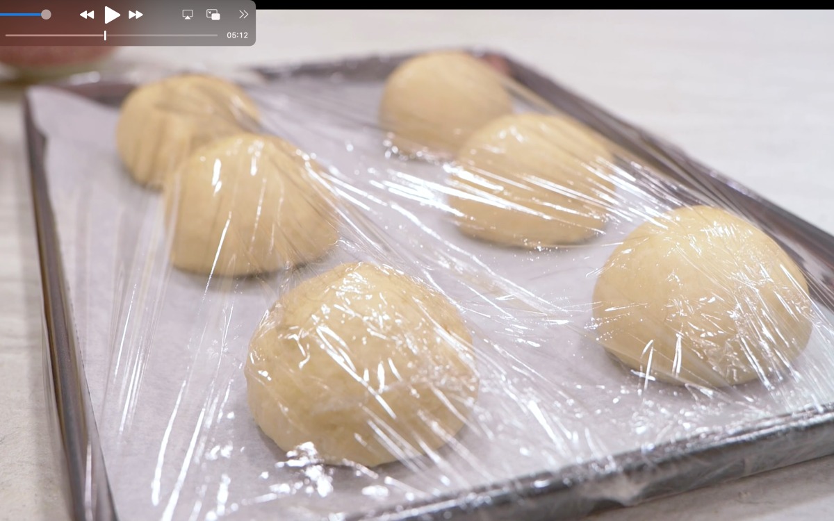 Sei palline di impasto per piadina romagnola coperte con pellicola trasparente a riposo