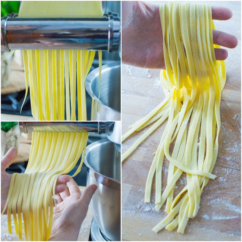 Tagliatelle fresche all'uovo che fuoriescono dal rullo tagliapastawhile una mano le raccoglie