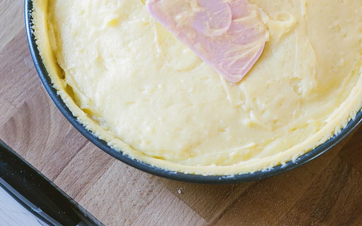 Crema pasticcera livellata con una spatola nel guscio di pasta frolla