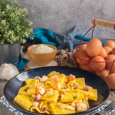 Carbonara di mare con pappardelle all'uovo, gamberi, pancetta a cubetti e salsa cremosa