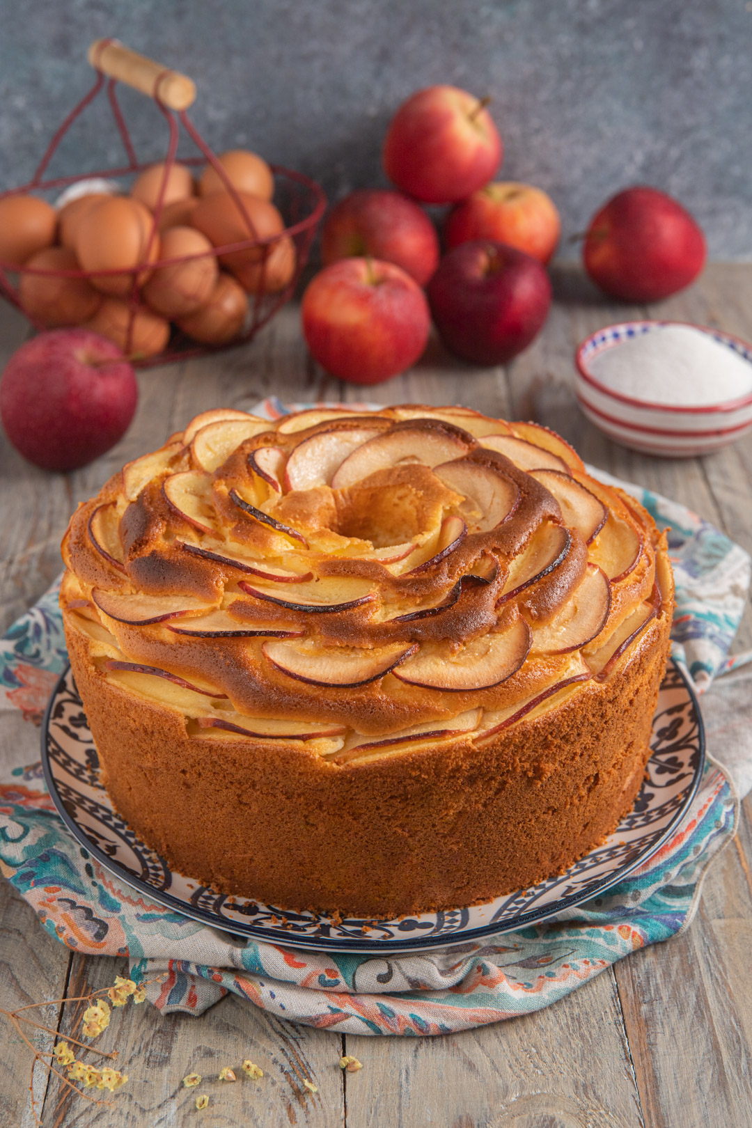 Chiffon cake alle mele sfornata con spicchi disposti a spirale sulla superficie dorata