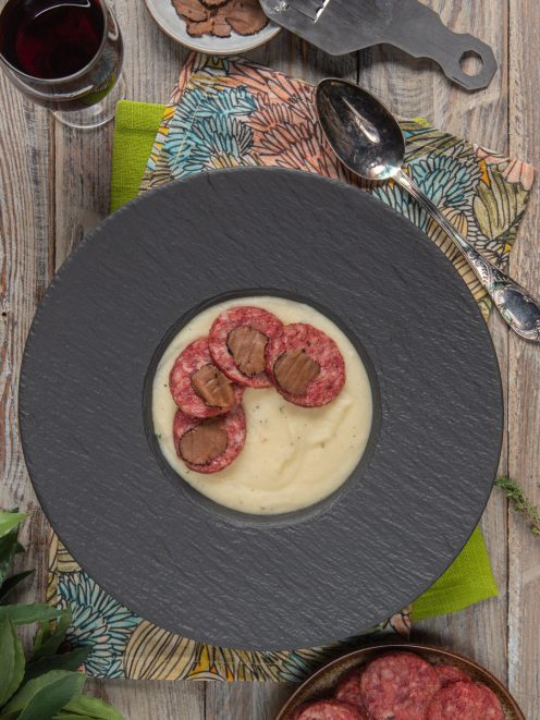 Crema di patate al tartufo con fette di cotechino croccante e lamelle di tartufo nero