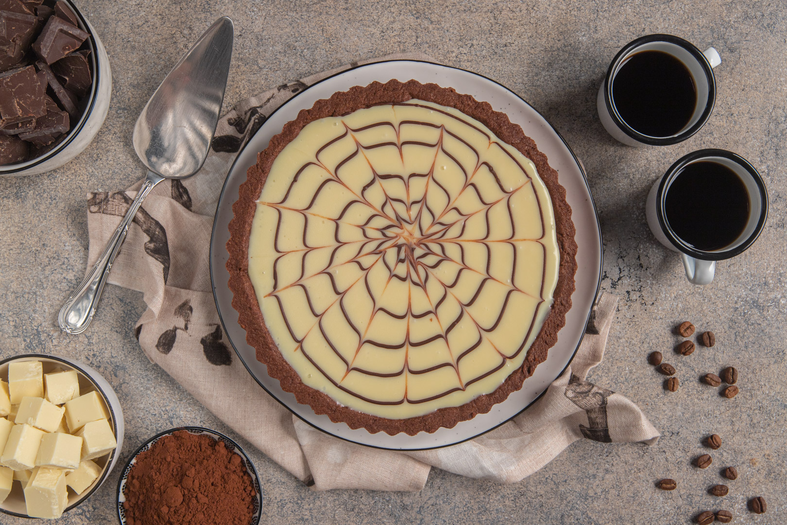 Crostata al cioccolato con superficie color crema decorata a ragnatela pronta per il taglio