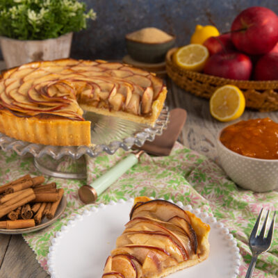 Crostata di mele con fettine disposte a spirale, glassate e servita a fette