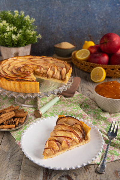 Crostata di mele con fettine disposte a spirale, glassate e servita a fette
