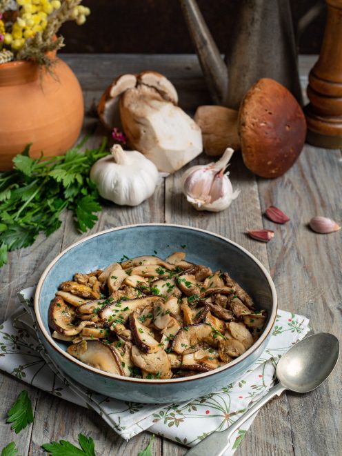 Funghi porcini trifolati a fette, saltati in padella e guarniti con prezzemolo tritato fresco