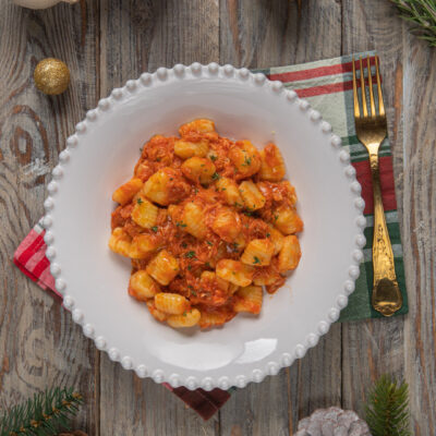 Gnocchi con sugo di faraona conditi con erbe fresche tritate, serviti in abbondante porzione