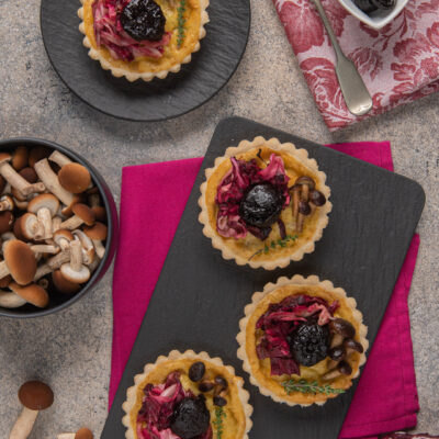 Mini quiche con radicchio, funghi, gorgonzola e prugne secche su base di pasta brisée