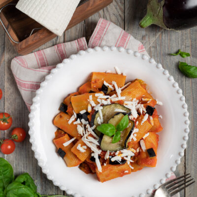 Pasta alla Norma con rigatoni al sugo di pomodoro, melanzane, ricotta salata grattugiata e basilico fresco