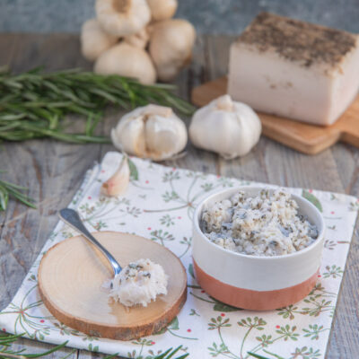 Pesto modenese con lardo, aglio e rosmarino servito in ciotola con un cucchiaio a lato