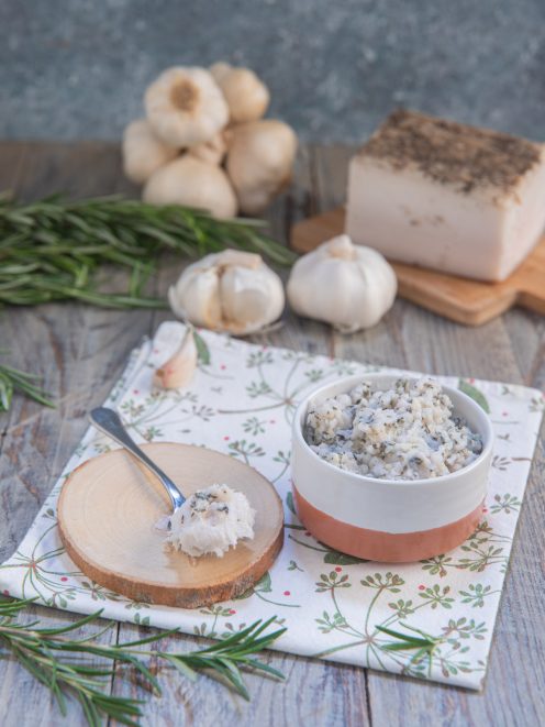 Pesto modenese con lardo, aglio e rosmarino servito in ciotola con un cucchiaio a lato