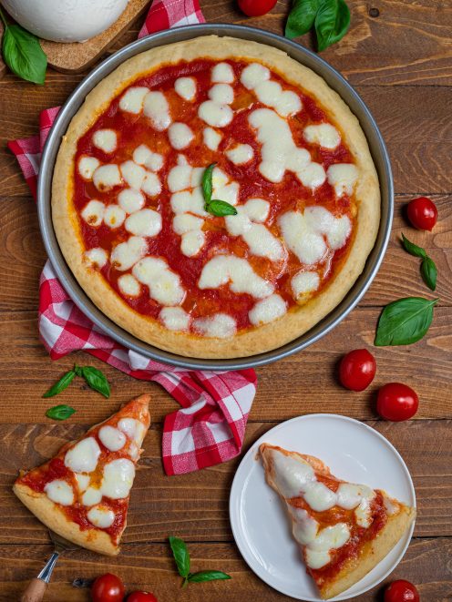 Pizza margherita con pomodoro, mozzarella a bocconcini e basilico fresco, servita a fette