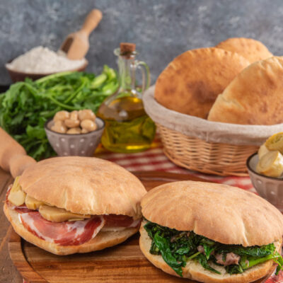 Puccia salentina farcita con prosciutto crudo e carciofi e con verdure saltate e carne