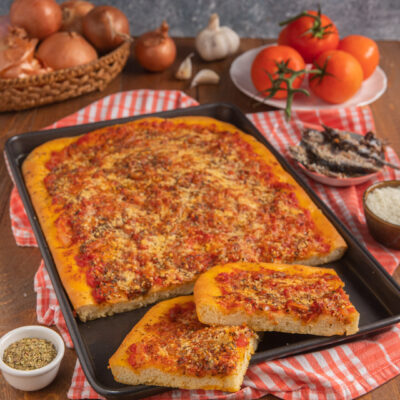 Rianata siciliana in teglia con pomodoro, origano e pangrattato, tagliata a porzioni