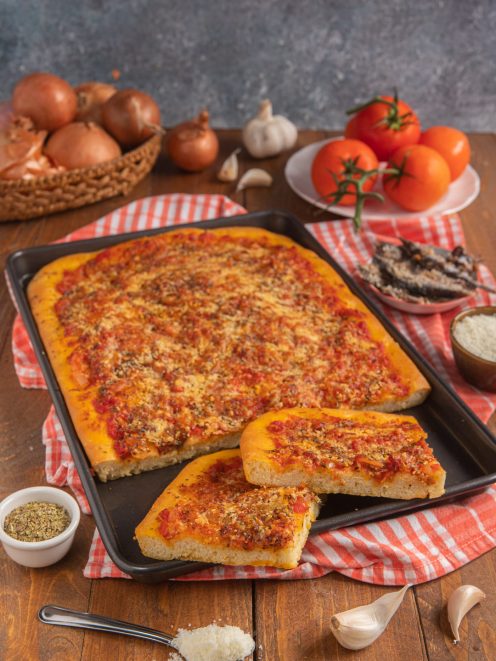 Rianata siciliana in teglia con pomodoro, origano e pangrattato, tagliata a porzioni