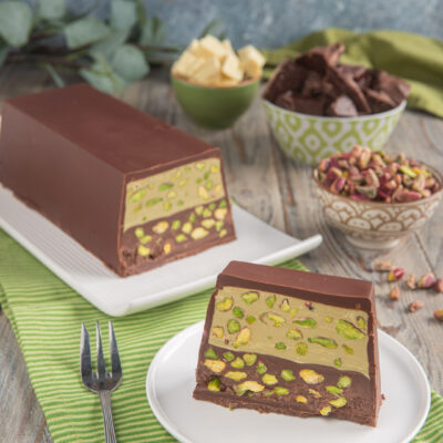 Torrone bigusto al pistacchio e cioccolato con strati di crema e granella, servito a fette