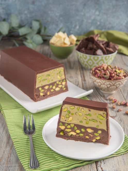 Torrone bigusto al pistacchio e cioccolato con strati di crema e granella, servito a fette