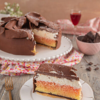 Torta Fedora toscana in sezione con strati di pan di Spagna, crema e copertura di cioccolato a scaglie