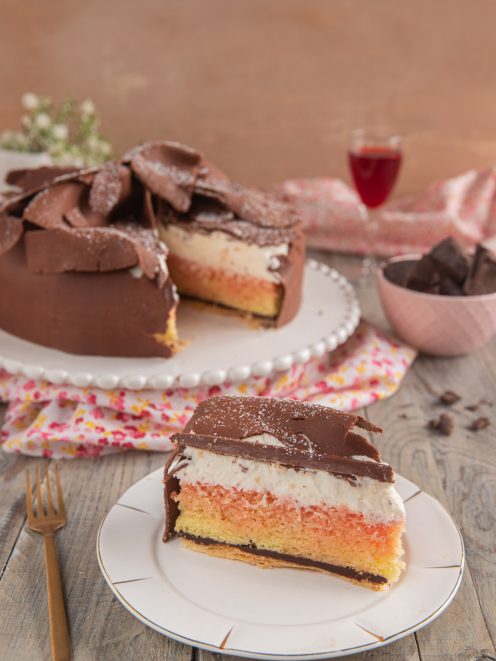 Torta Fedora toscana in sezione con strati di pan di Spagna, crema e copertura di cioccolato a scaglie