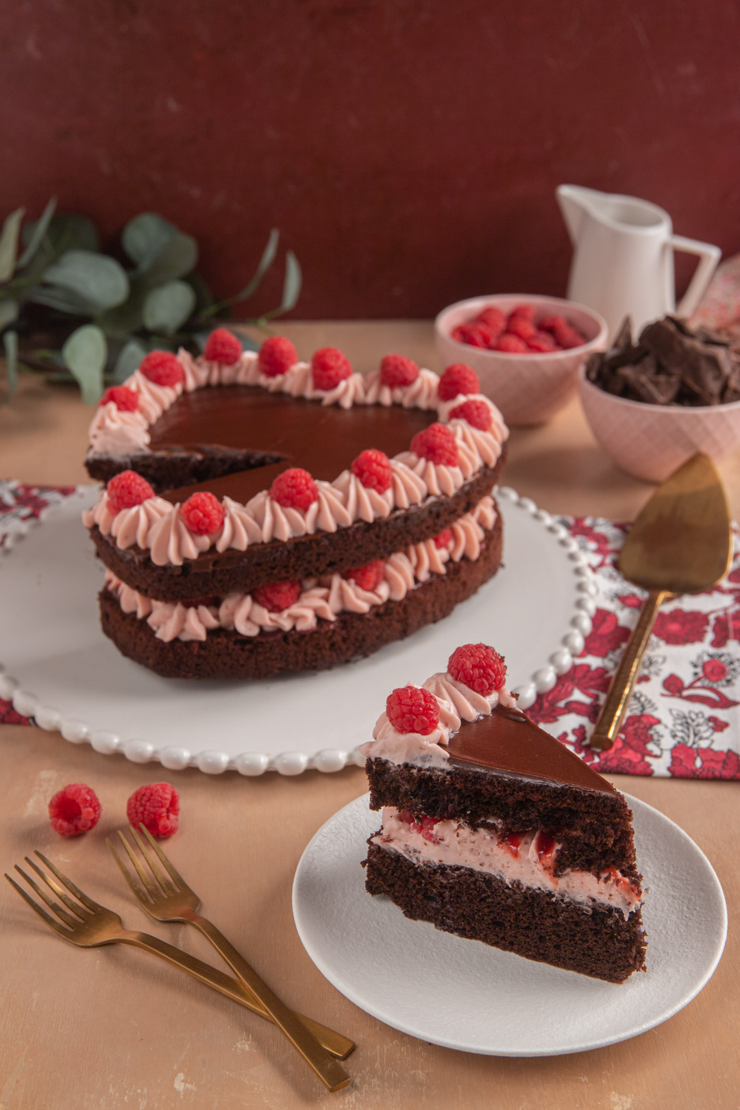 Torta cuore al cioccolato e lamponi tagliata a fette con farcitura di crema e lamponi freschi