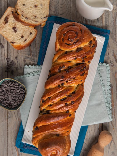 Treccia russa intrecciata con gocce di cioccolato, dorata in superficie, con fette tagliate a lato