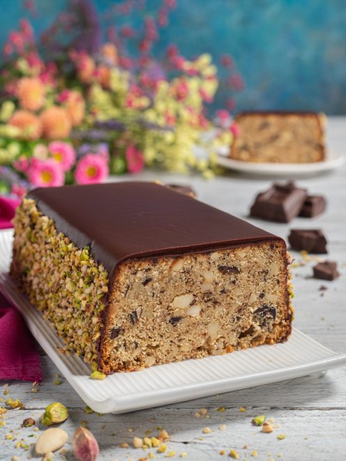 Amandolvolo a fette con glassa al cioccolato e bordo di granella di pistacchi e mandorle