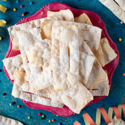 Chiacchiere senza glutine fragranti, coperte di zucchero a velo e servite in abbondanza