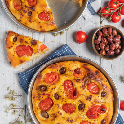 Focaccia barese con pomodorini ciliegia arrosto, olive e origano, servita in teglia