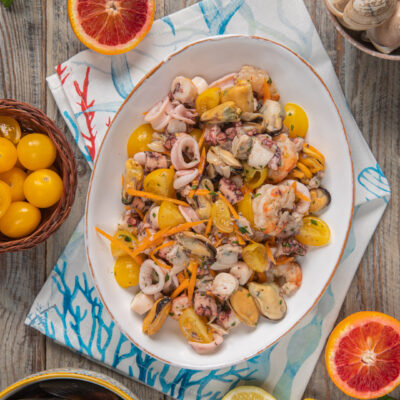 Insalata di mare con polpo, cozze, gamberi, calamari, pomodorini gialli e carote julienne