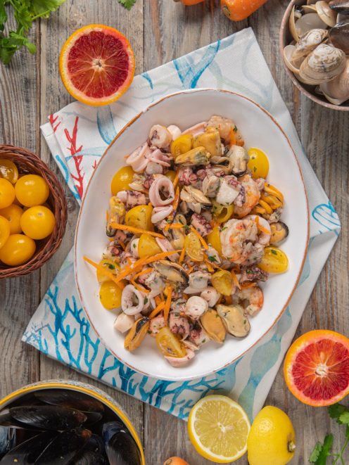 Insalata di mare con polpo, cozze, gamberi, calamari, pomodorini gialli e carote julienne