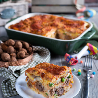 Lasagne di Carnevale con strati di ragù, piselli e besciamella, gratinate e servite a fetta