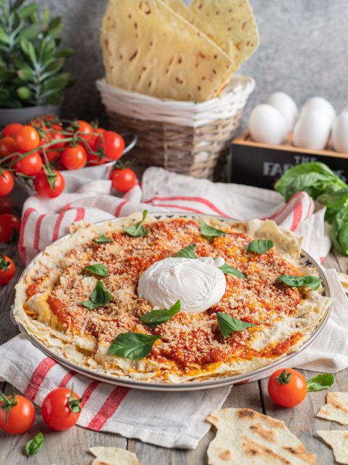 Pane frattau con salsa di pomodoro, parmigiano grattugiato, burrata al centro e foglie di basilico