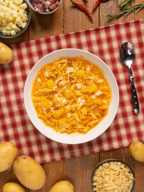 Pasta patate e provola in brodo di pomodoro con pezzi di patata e filamenti di formaggio fuso