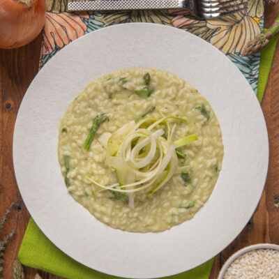 Risotto agli asparagi mantecato, guarnito con julienne di porro al centro