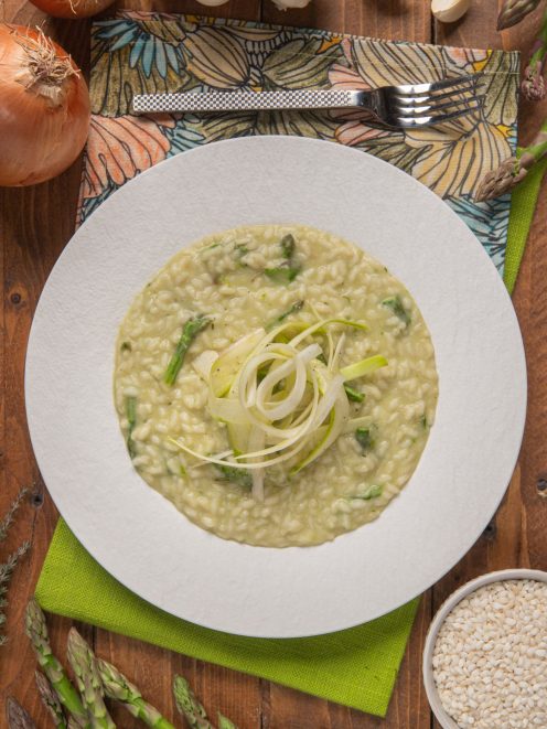 Risotto agli asparagi mantecato, guarnito con julienne di porro al centro