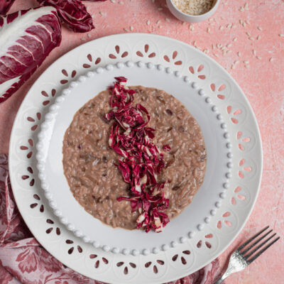 Risotto al radicchio mantecato e cremoso, guarnito con striscioline di radicchio fresco al centro