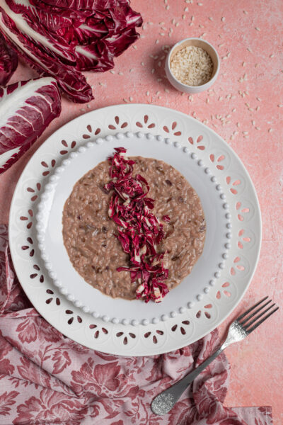 Risotto al radicchio mantecato e cremoso, guarnito con striscioline di radicchio fresco al centro
