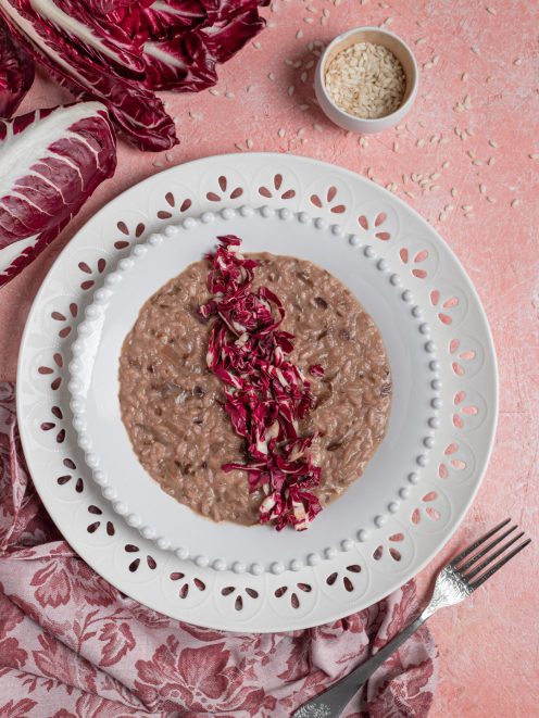 Risotto al radicchio mantecato e cremoso, guarnito con striscioline di radicchio fresco al centro