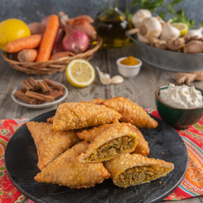 Samosa fritti con pasta croccante e ripieno di carne speziata, uno tagliato a metà