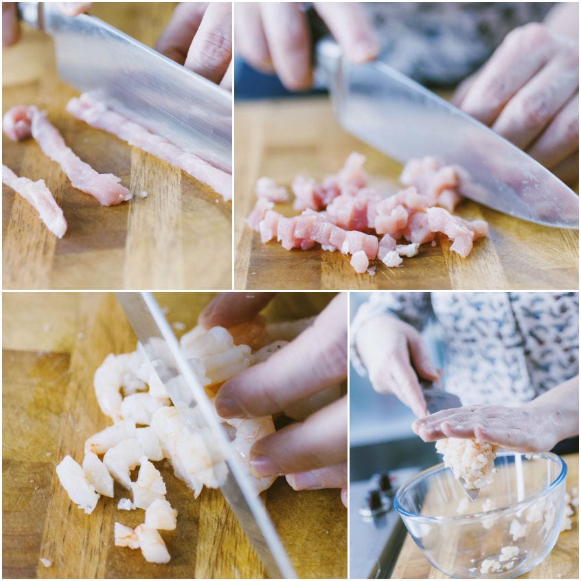 Lonza e gamberi tagliati a coltello in piccoli pezzi sul tagliere prima di unirli nella ciotola