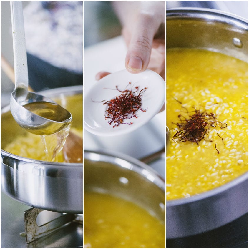 Pistilli di zafferano aggiunti al risotto in cottura, con il brodo versato a mestoli