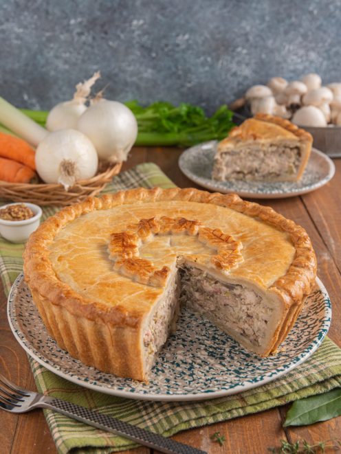 Chicken pie con pasta dorata e decorata, tagliata a mostrare il ripieno di pollo