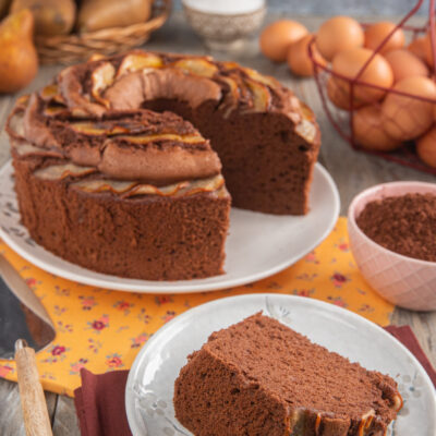 Chiffon cake alle pere e cioccolato con fette di pera caramellata, una porzione tagliata in primo piano